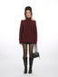 Model wearing a maroon knit sweater with open shoulders, black shorts, star-patterned tights, and black knee-high boots.