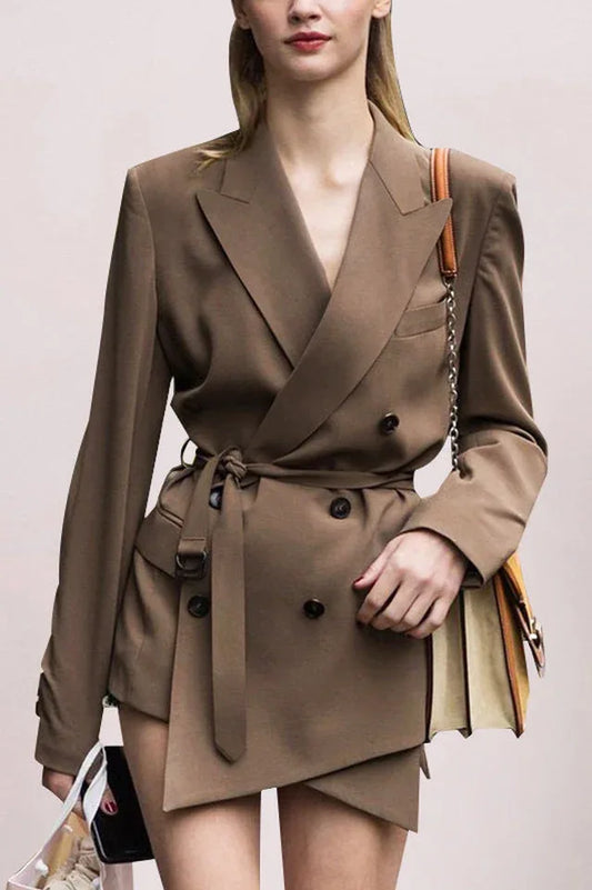 Model wearing a brown double-breasted blazer with a belted waist and asymmetrical hem.
