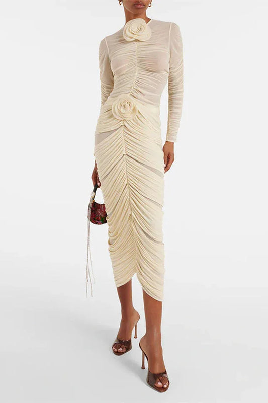 Woman wearing a cream ruched mesh dress with floral embellishments and long sleeves