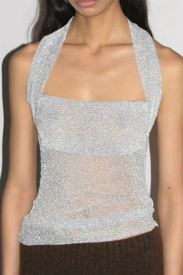 Close-up of a silver sparkly halter top with a sheer lower panel.