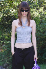 woman wearing a light blue ruched halter top and black shorts outdoors