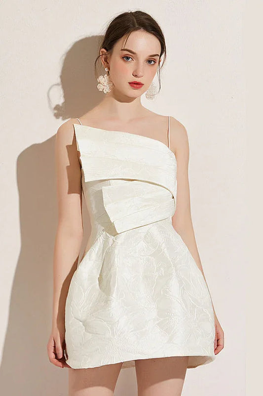 Woman wearing a white asymmetrical neckline dress with a textured floral pattern and spaghetti straps.