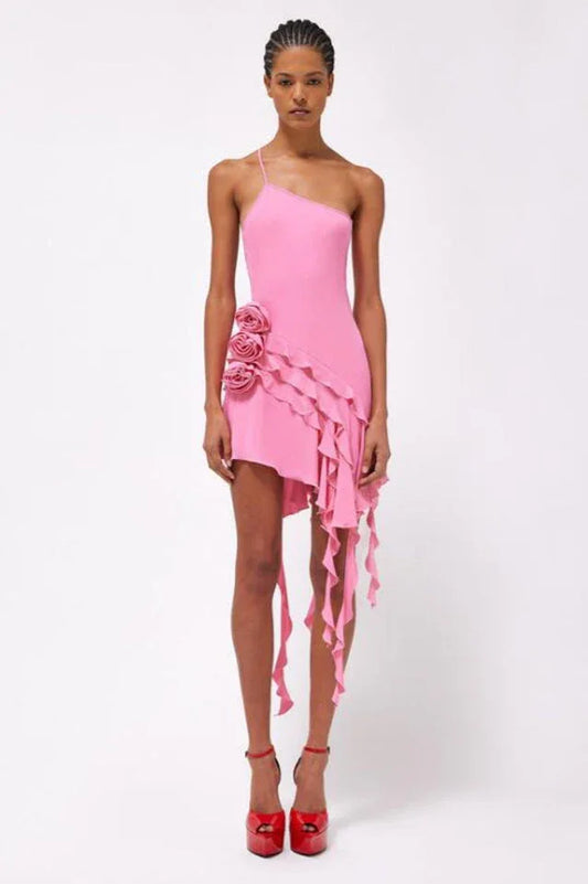 woman wearing a pink one-shoulder mini dress with rose embellishments and ruffled asymmetrical hemline