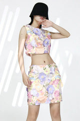 Model wearing a floral crop top and mini skirt set with a hat, front view