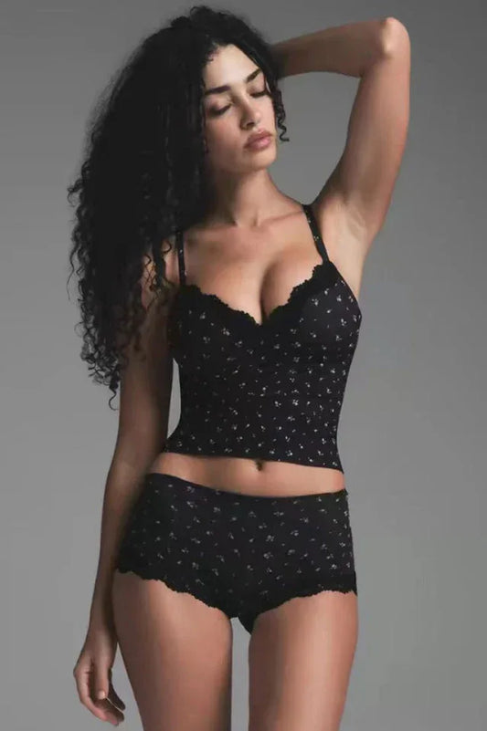 Woman wearing a black floral print camisole and matching briefs