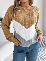 Woman wearing a brown, white, and grey colorblock chevron knit sweater with blue jeans