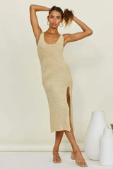 Woman with hands on hips wearing a beige knit midi dress with a high slit