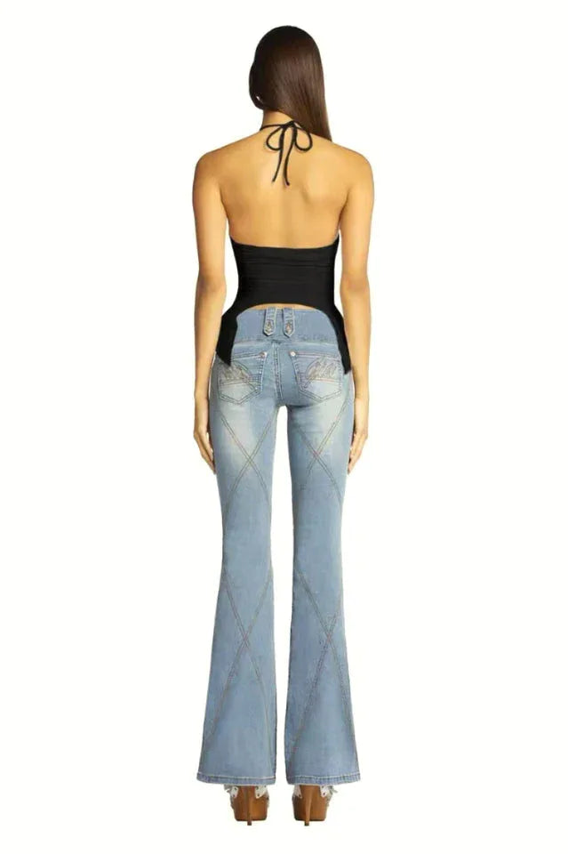 Back view of a woman wearing a black halter top and light wash flared jeans.