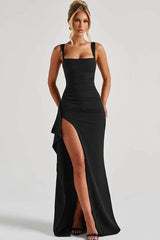 Woman in a black sleeveless floor-length gown with a high slit and square neckline
