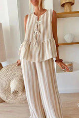 Woman in a beige and white striped matching set featuring a tie-front top and wide leg pants.