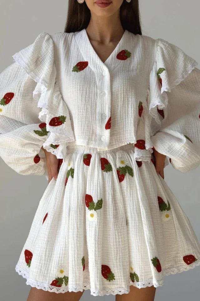 Close-up of the white strawberry print blouse and skirt, highlighting the fabric texture and embroidery details.
