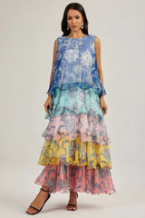 Woman wearing a blue, teal, pink, yellow, and pink tiered maxi dress with a floral print and ruffled hem.