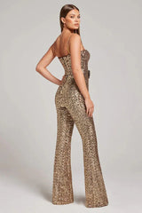 Rear view of a woman wearing a gold sequined jumpsuit with a sweetheart neckline and wide legs.