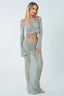 Woman wearing a light blue crochet knit crop top and maxi skirt set, side view.