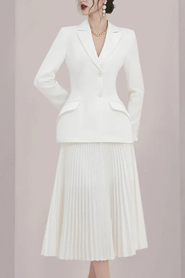 Woman in a white pleated skirt suit with hands behind back