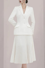 Woman in a white pleated skirt suit with hands behind back