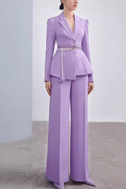 Woman wearing a lavender peplum suit with wide-leg trousers and a pearl belt