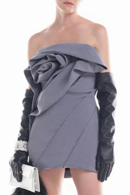 Model wearing a grey strapless dress with a rose-inspired bodice, black opera gloves, and a white clutch.
