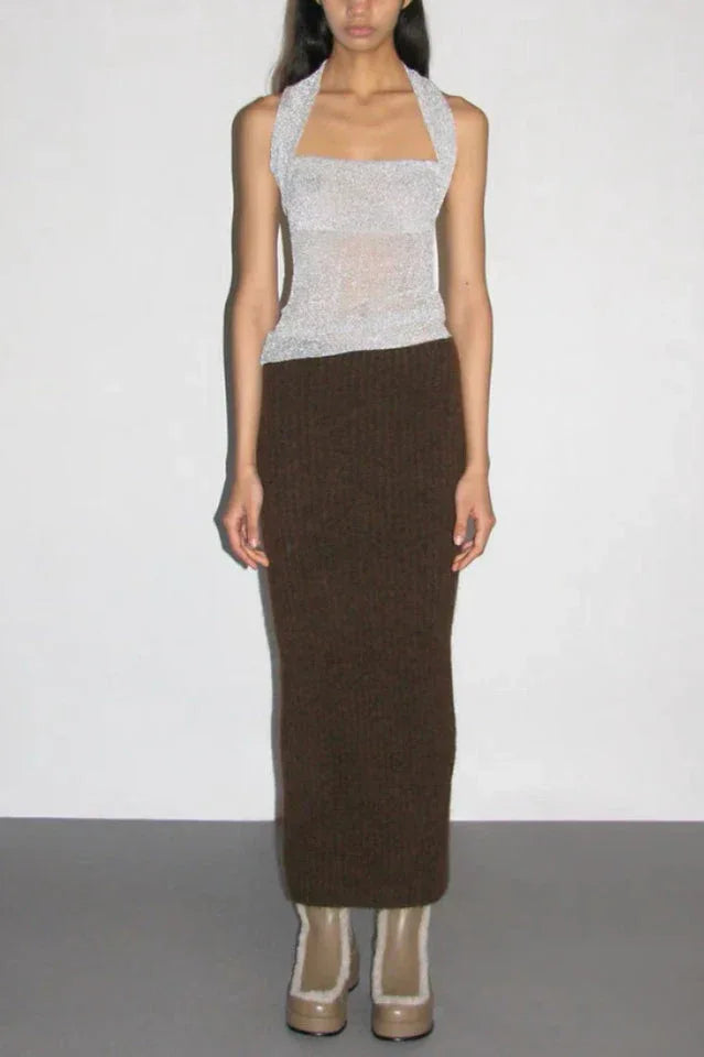 Full body shot of a model wearing a silver sparkly halter top and a brown knit maxi skirt.