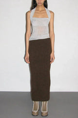 Full body shot of a model wearing a silver sparkly halter top and a brown knit maxi skirt.