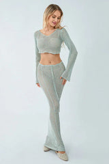 Woman wearing a light blue crochet knit crop top and maxi skirt set, front view.