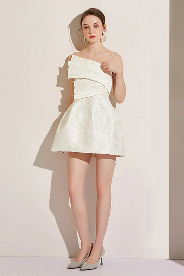 Full body shot of a woman in a white asymmetrical neckline dress with a short A-line skirt.