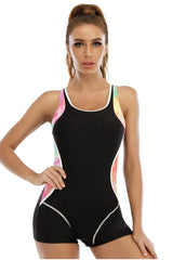 Woman wearing a black one-piece swimsuit with colorful tie-dye side panels and white trim.