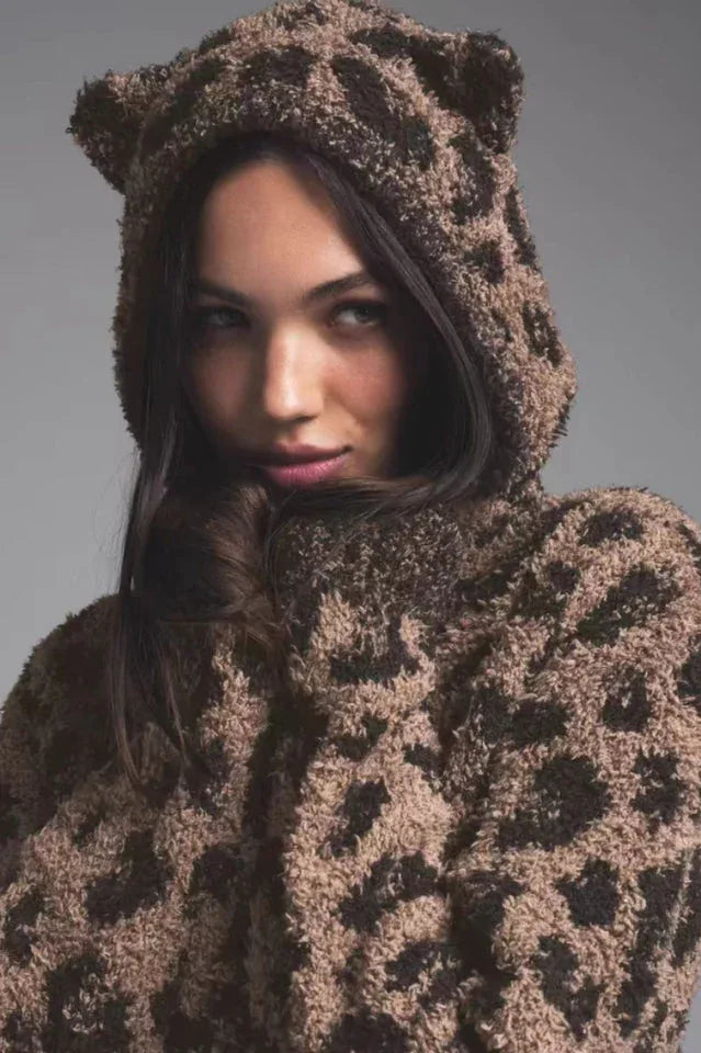 Close-up of a woman wearing a leopard print fuzzy hood with ear details.