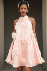 Model wearing a pink satin halter dress with 3D floral appliqués and rhinestone embellishments on the collar.