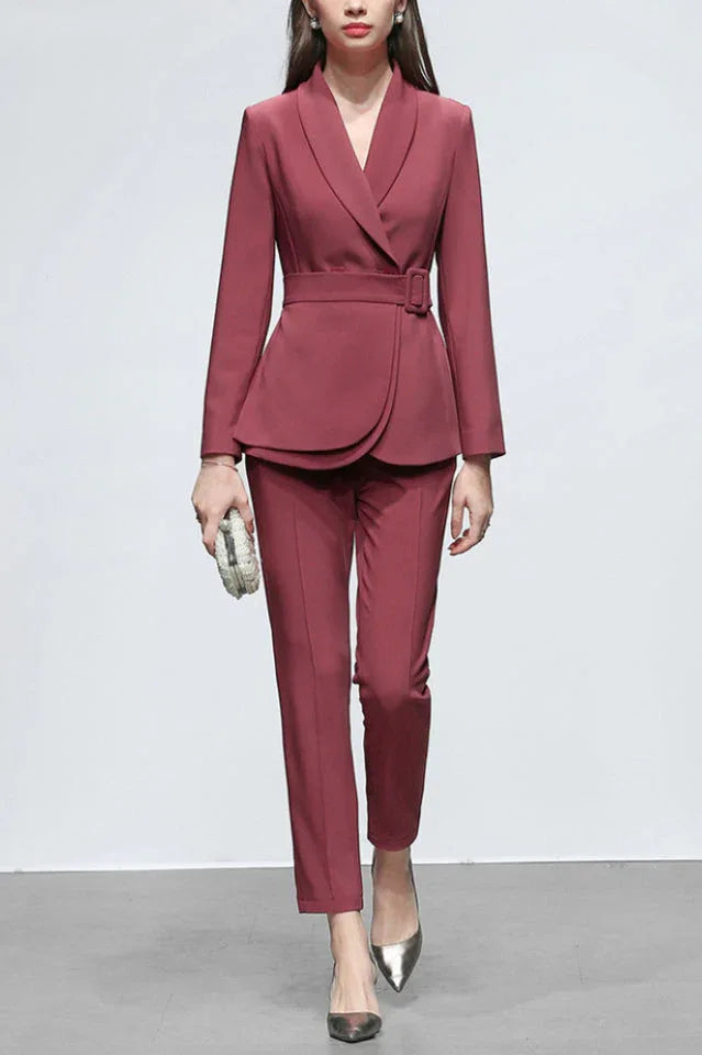 Front view of a woman in a deep red business suit, highlighting the notched lapel and tailored trousers.