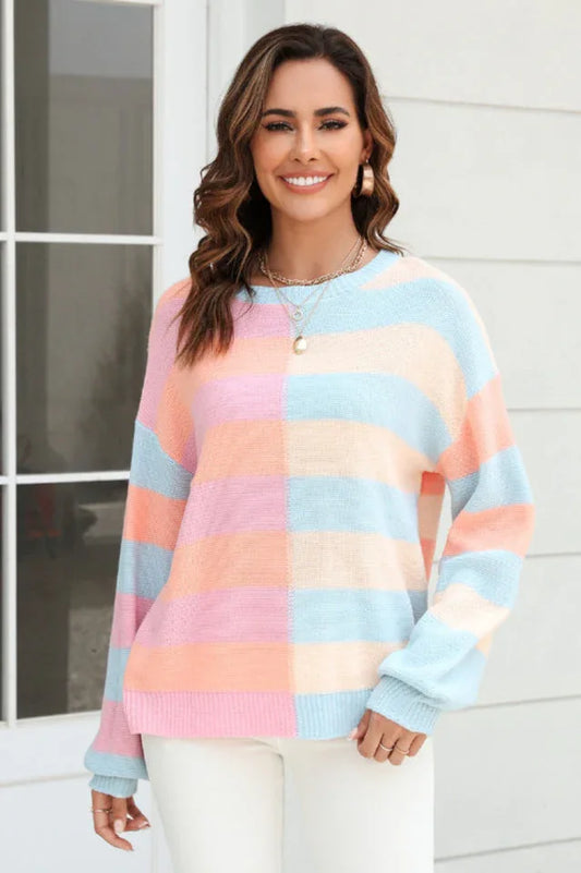 Woman wearing a pastel striped color-block knit sweater with white pants