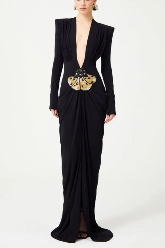 Black long-sleeved gown with a plunging V-neckline and a draped skirt, featuring a jeweled butterfly embellishment at the waist.