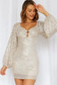 Woman wearing a silver sequined mini dress with long puff sleeves and a square neckline.