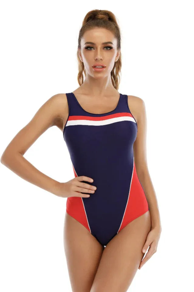 Woman wearing a navy and red one-piece swimsuit with white stripe accent