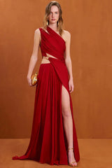 Woman wearing a red one-shoulder draped chiffon gown with a high slit and gold ring detail, holding a gold clutch.