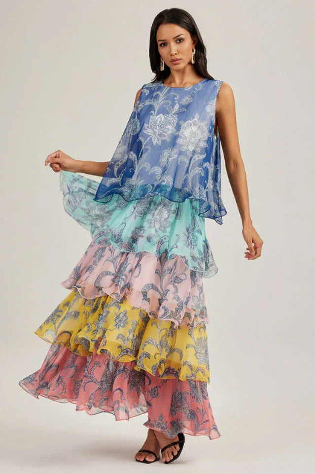 Model showcasing a sleeveless, tiered maxi dress in a gradient of blues, greens, and pinks.