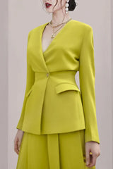 Close-up of a woman wearing a lime green lapel blazer with a V-neck.