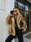 Woman wearing a tan and brown faux fur cropped jacket with black pants and black gloves.