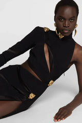 Close-up of the black asymmetrical mini dress showcasing the cut-out details and satin trim.