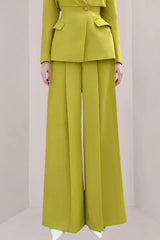 Close-up of a woman wearing lime green wide-leg pants with pleats.