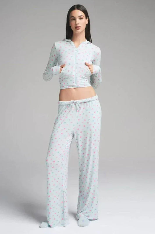 Woman wearing a light blue cropped hoodie with pink and blue heart prints and matching wide-leg pants.