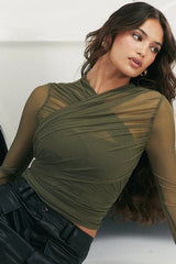 Close-up of the front of a woman's green ruched mesh top.