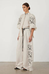 Close-up of the embroidered collar and puff sleeves of a linen shirt