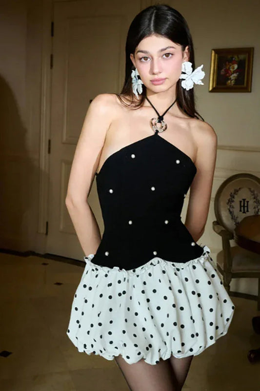 Model wearing a black halter neck dress with white polka dot bubble skirt