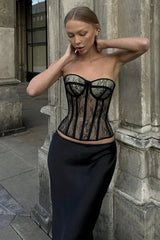 Woman wearing a black lace corset top and a black skirt outdoors