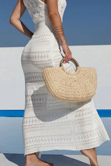 Close-up of a woman's side profile wearing a white crochet knit maxi dress and holding a straw handbag.