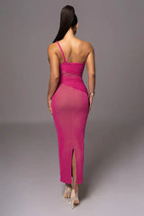 Back view of a woman in a hot pink, one-shoulder, ruched dress with a side slit.