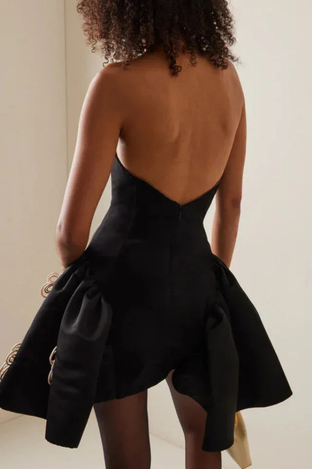 Back view of a woman in a black strapless dress with a low back