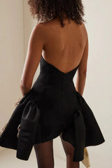 Back view of a woman in a black strapless dress with a low back