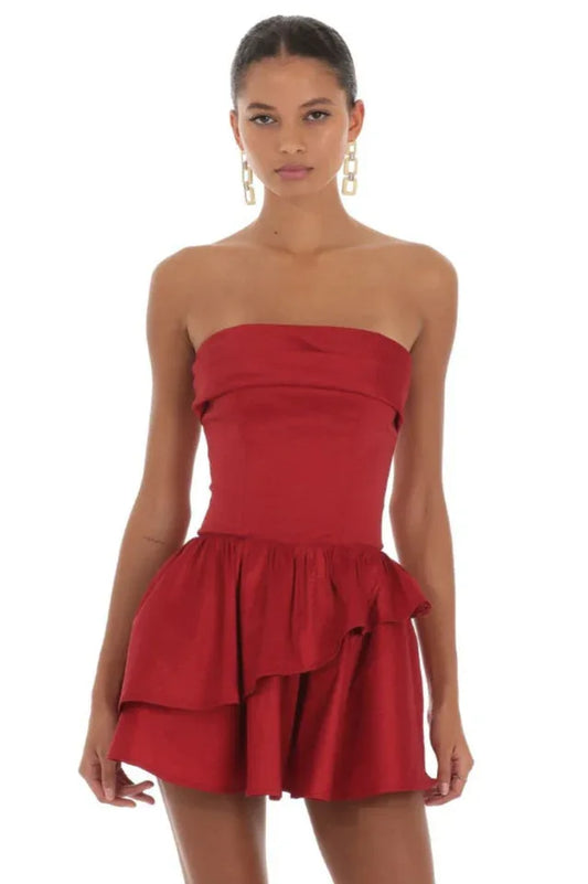 Woman wearing a red strapless mini dress with a tiered ruffled skirt and lace-up back detail, shown from the front.